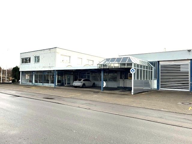 Ein weißes Gebäude mit einem davor geparkten Auto.