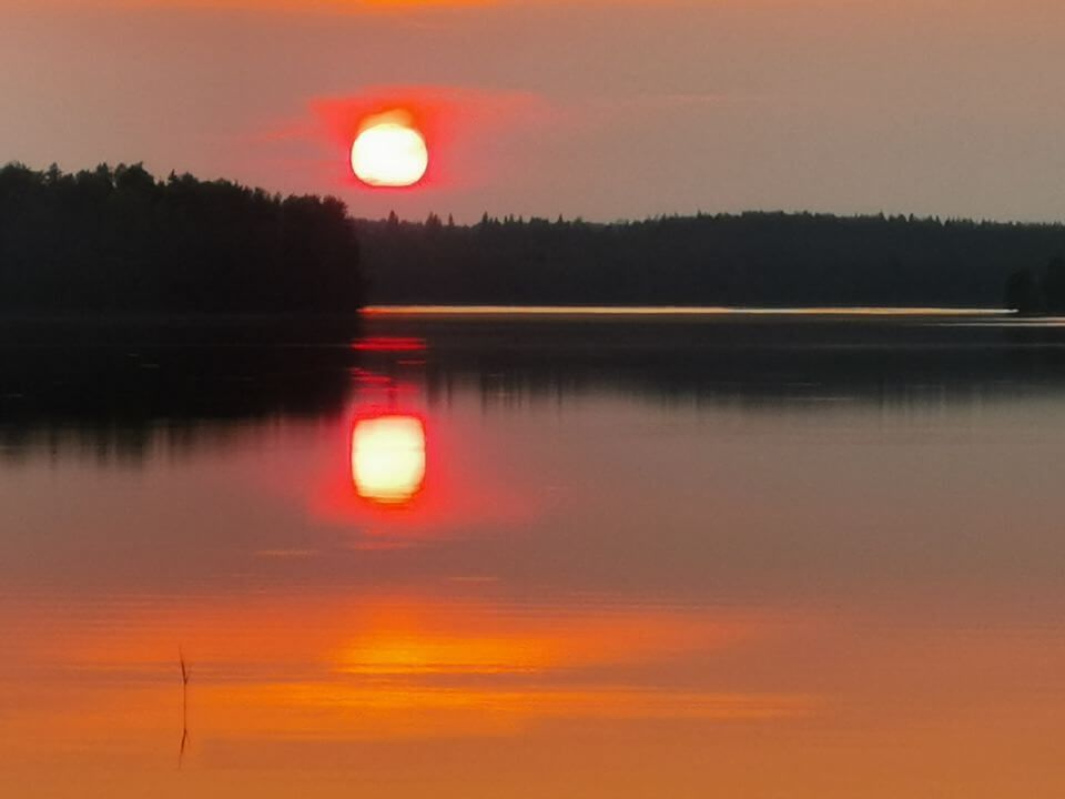 Yöaurinko järven yllä