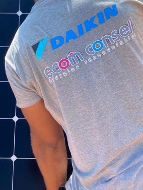 Personne installant un panneau solaire, portant une chemise avec le logo « DAIKIN ecom conseil ».