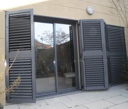 Una puerta corrediza de vidrio con persianas negras.