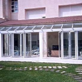 Una casa grande con muchas ventanas y techo de cristal.