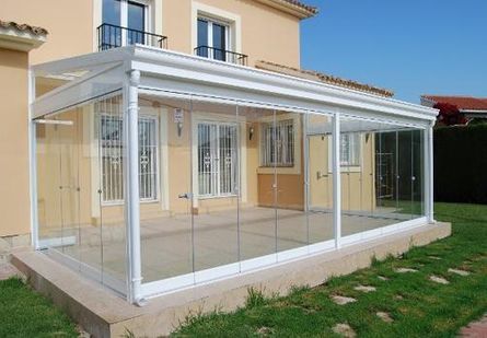 Una casa con un patio con puertas corredizas de vidrio y un toldo.