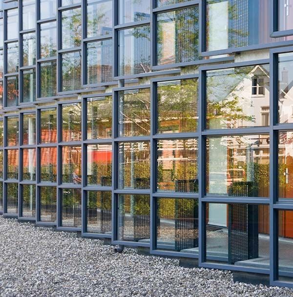 Un edificio con muchas ventanas tiene mucha grava delante.