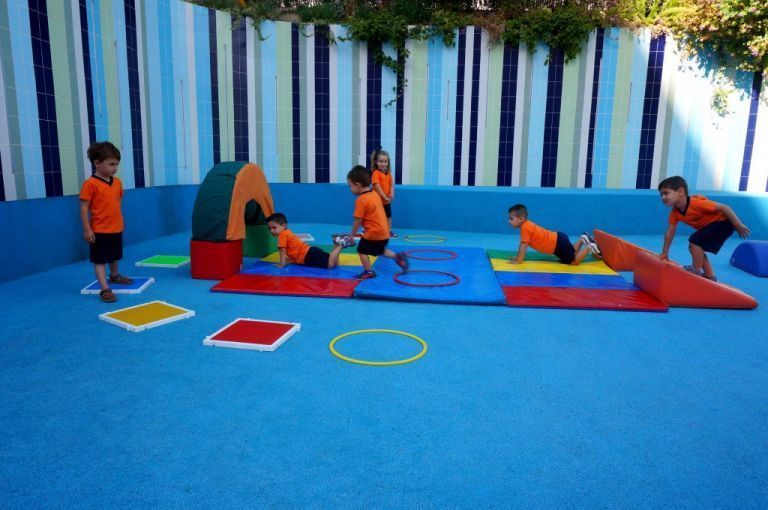 Un grupo de niños está jugando en un colorido patio de recreo.