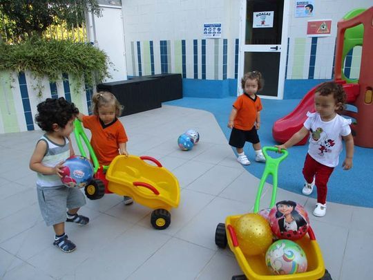 Un grupo de niños está jugando con juguetes en un patio de recreo.
