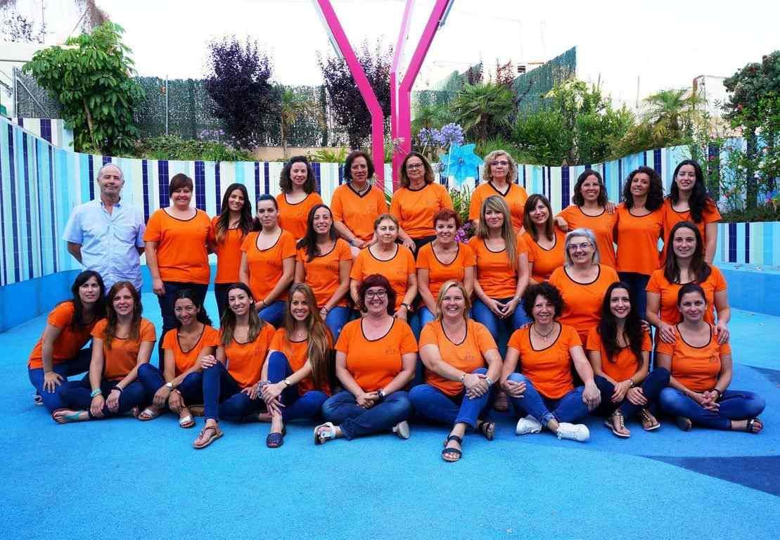 Un grupo de mujeres con camisetas naranjas posan para una foto.