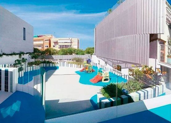 Impresión artística de un parque infantil entre dos edificios.