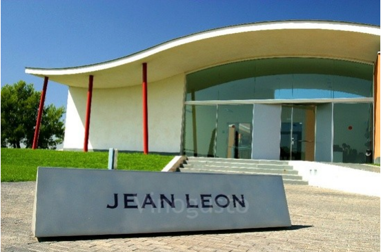 Entrada de la bodega Jean Leon con un cartel de hormigón en un día soleado.