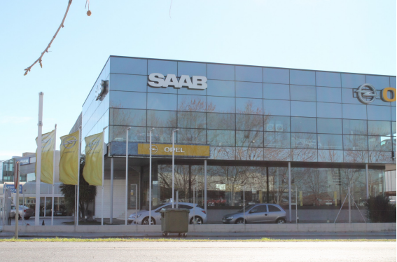 Edificio de concesionarios de Saab y Opel con fachada de cristal. Vista exterior en un día soleado.