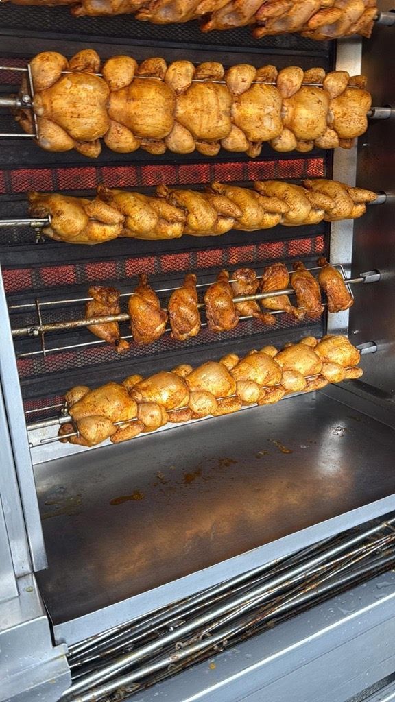 Brathähnchen, die in einem gewerblichen Ofen garen, Reihen von ganzen Vögeln.