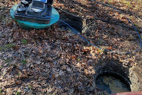 Engin de chantier bleu sur un sol boueux près d'un petit trou rempli d'eau
