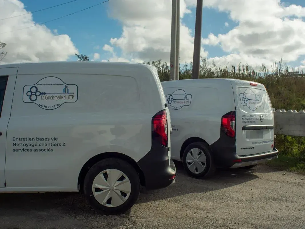 Une excavatrice déverse des débris dans une benne à ordures sur un chantier de construction résidentielle.