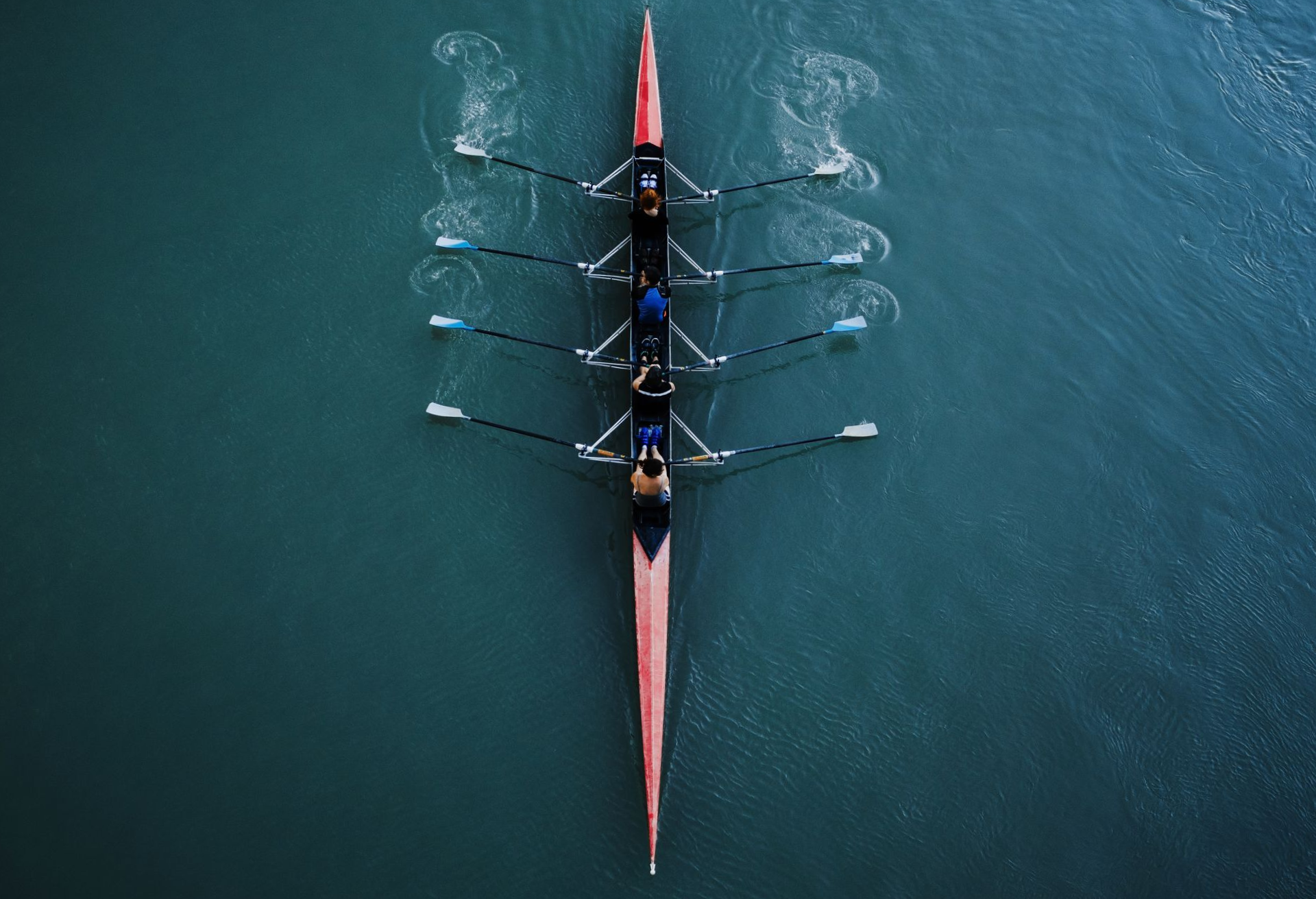 Une équipe qui fait de l'aviron vue de dessus.