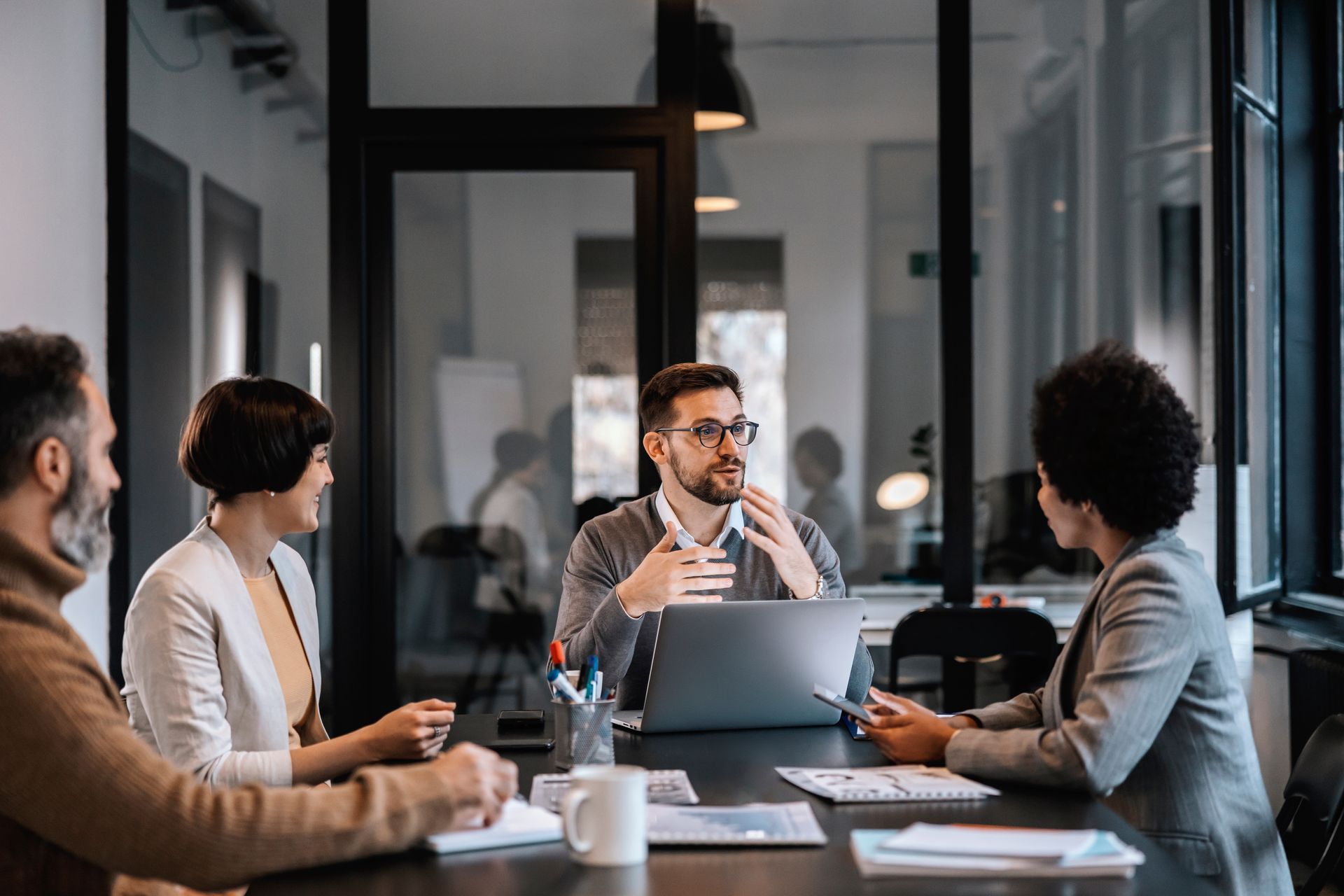 Des collaborateurs échangent autour d'une table de réunion.