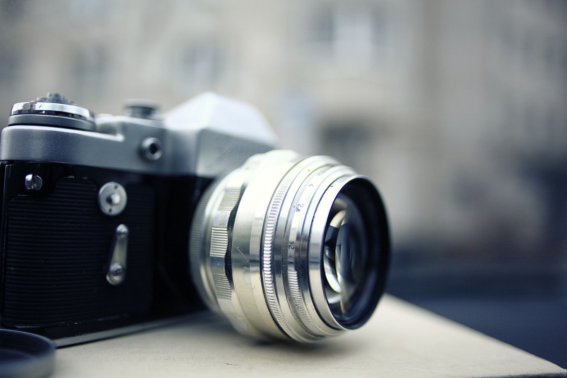 Un appareil photo argentique avec un objectif posé quelque part.