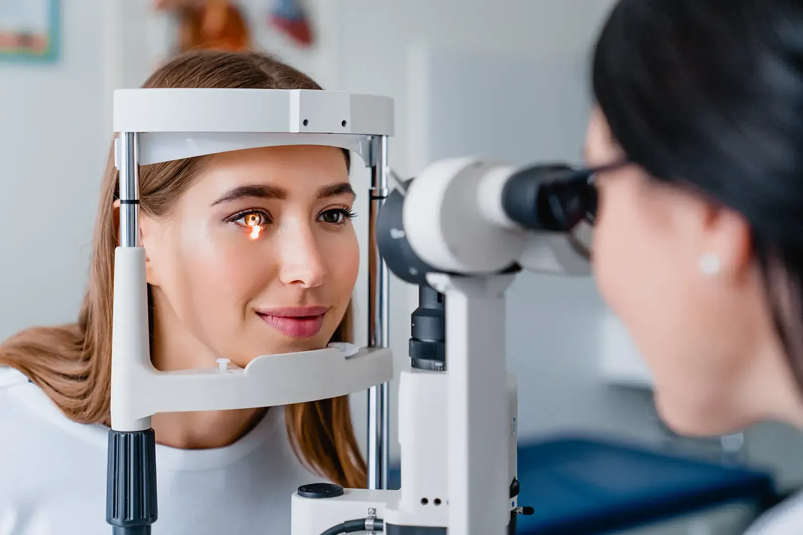 Optiker untersucht die Augen einer Frau mit einer Spaltlampe in einer Klinik