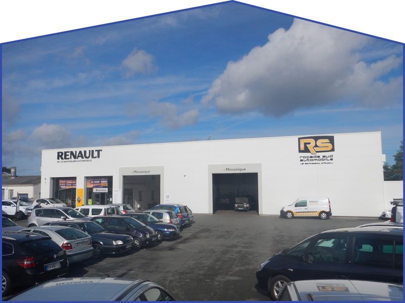 Concessionnaire Renault avec voitures garées, bâtiment blanc, ciel bleu.
