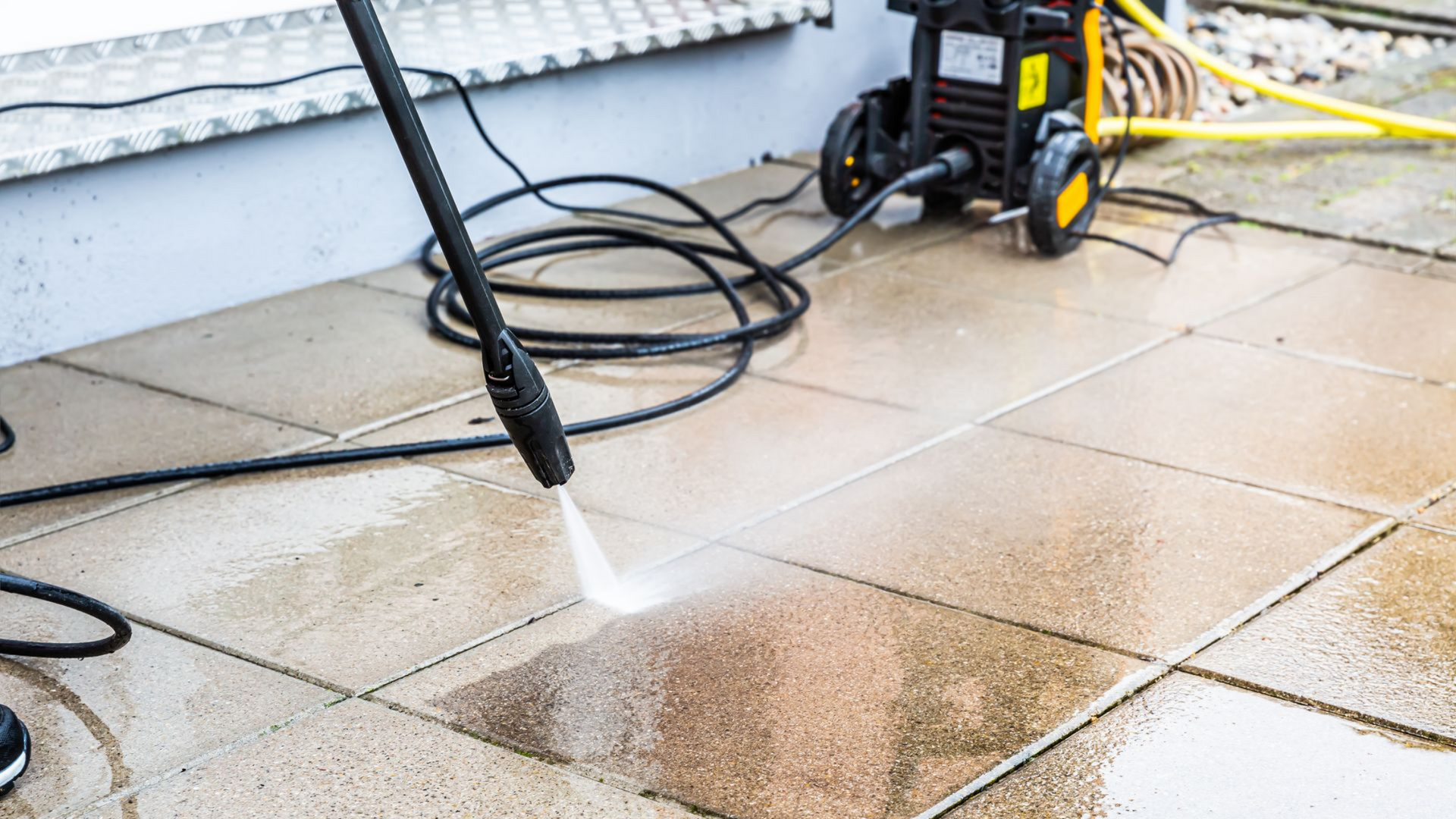 Nettoyage haute pression sur une terrasse extérieure.