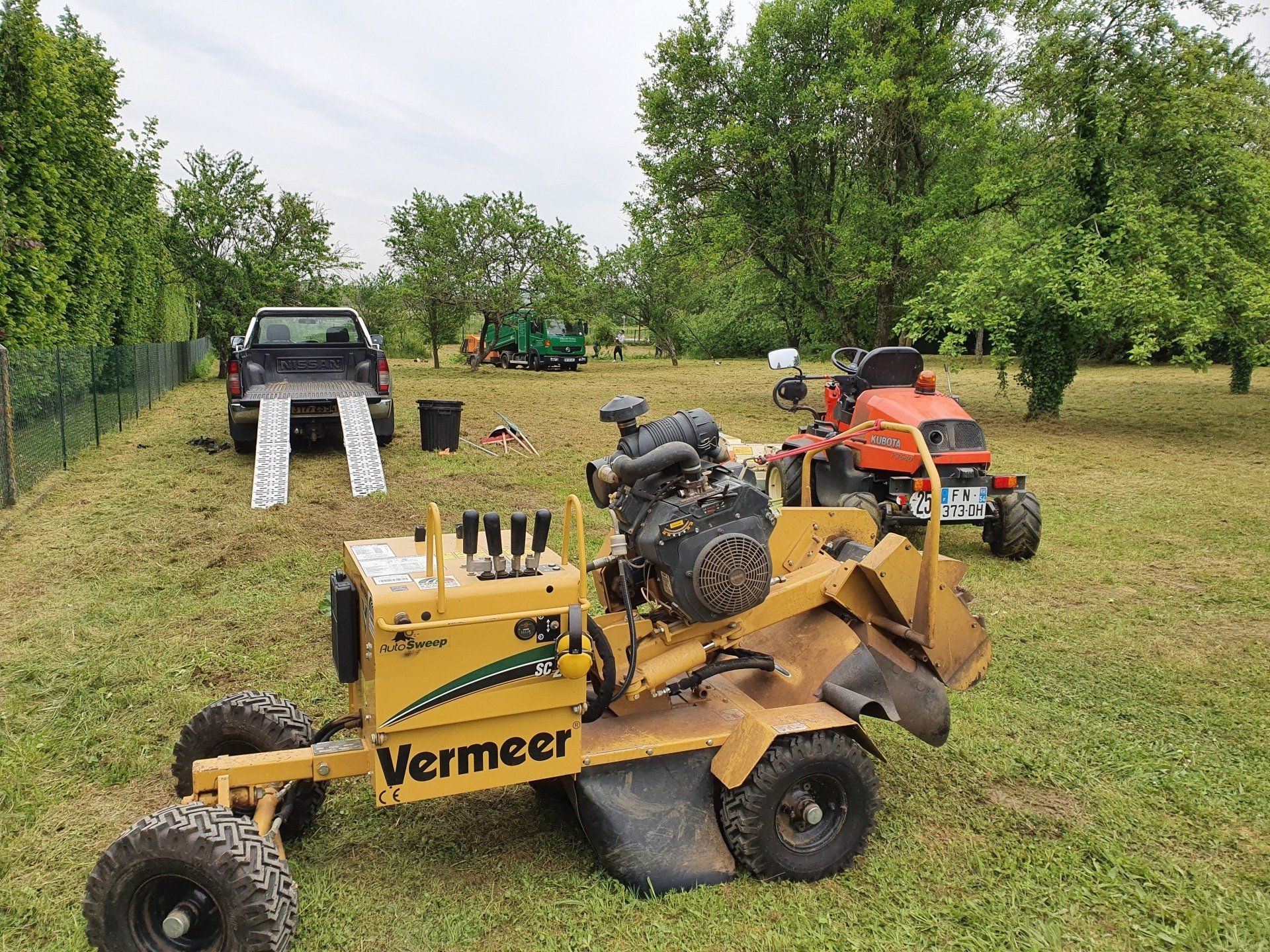 Engins jaune, engin rouge et camion-benne vert