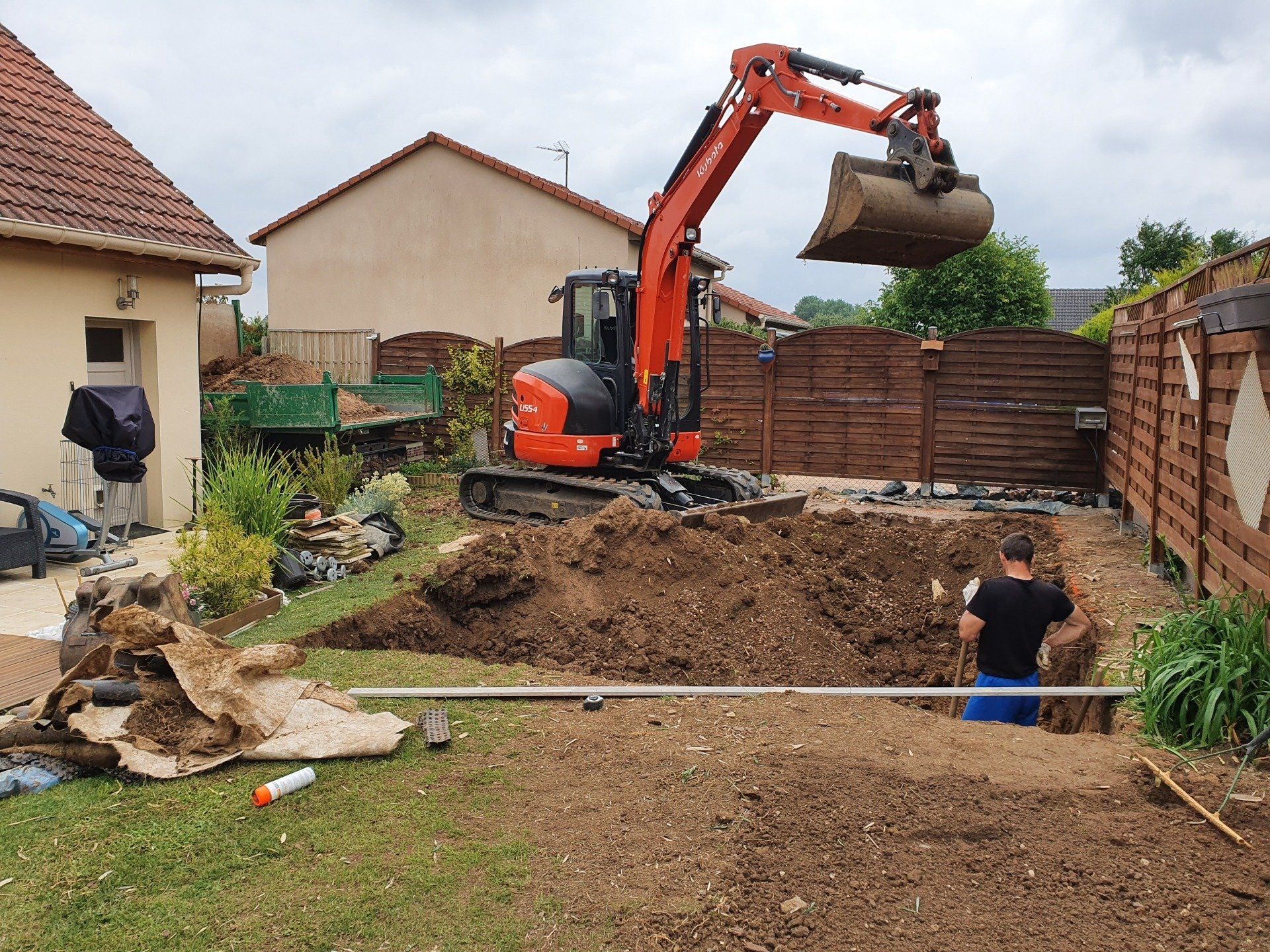 Terrassement d'une piscine avec une minipelle orange