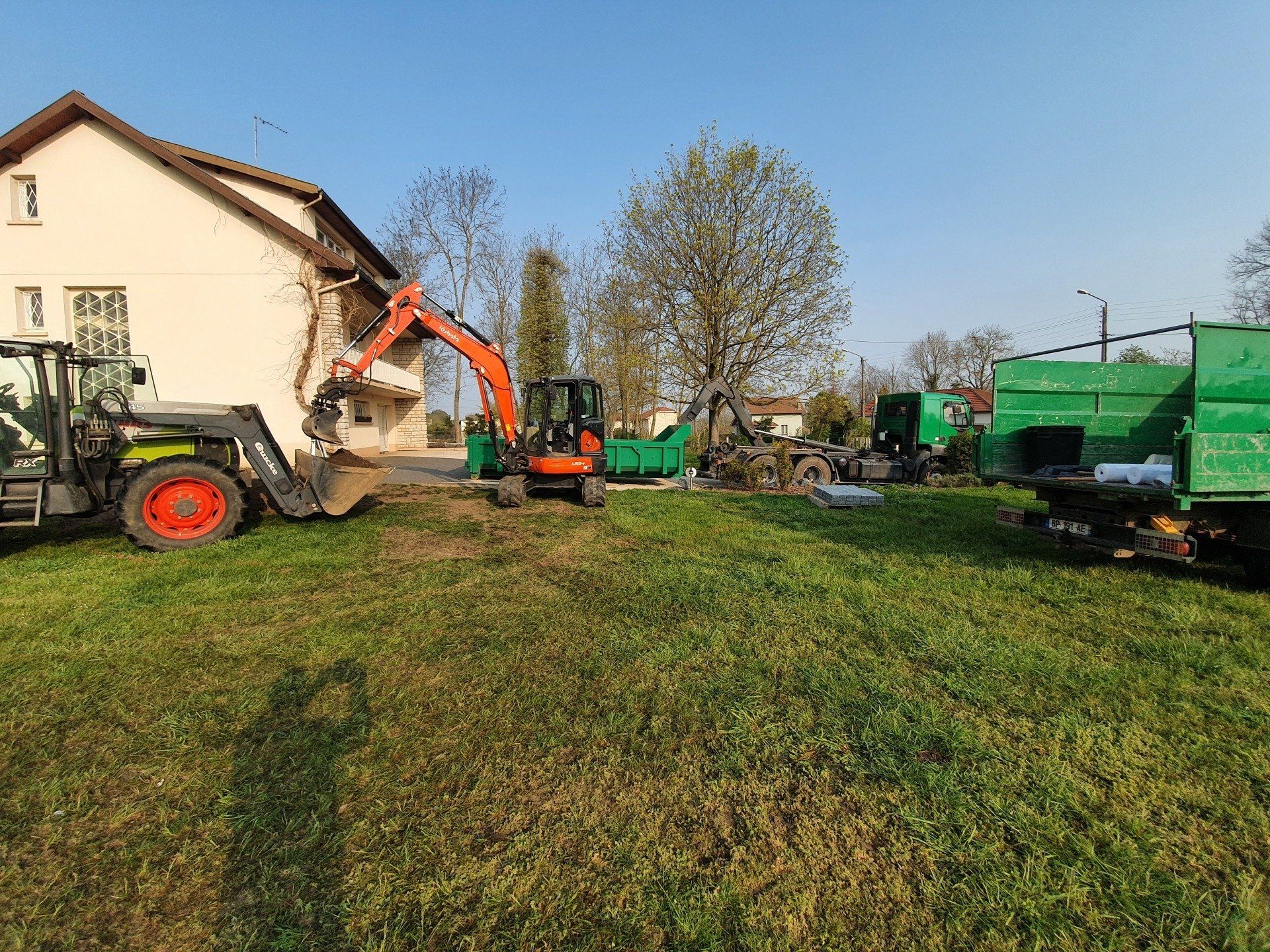 Différents engins avec une benne verte à droite