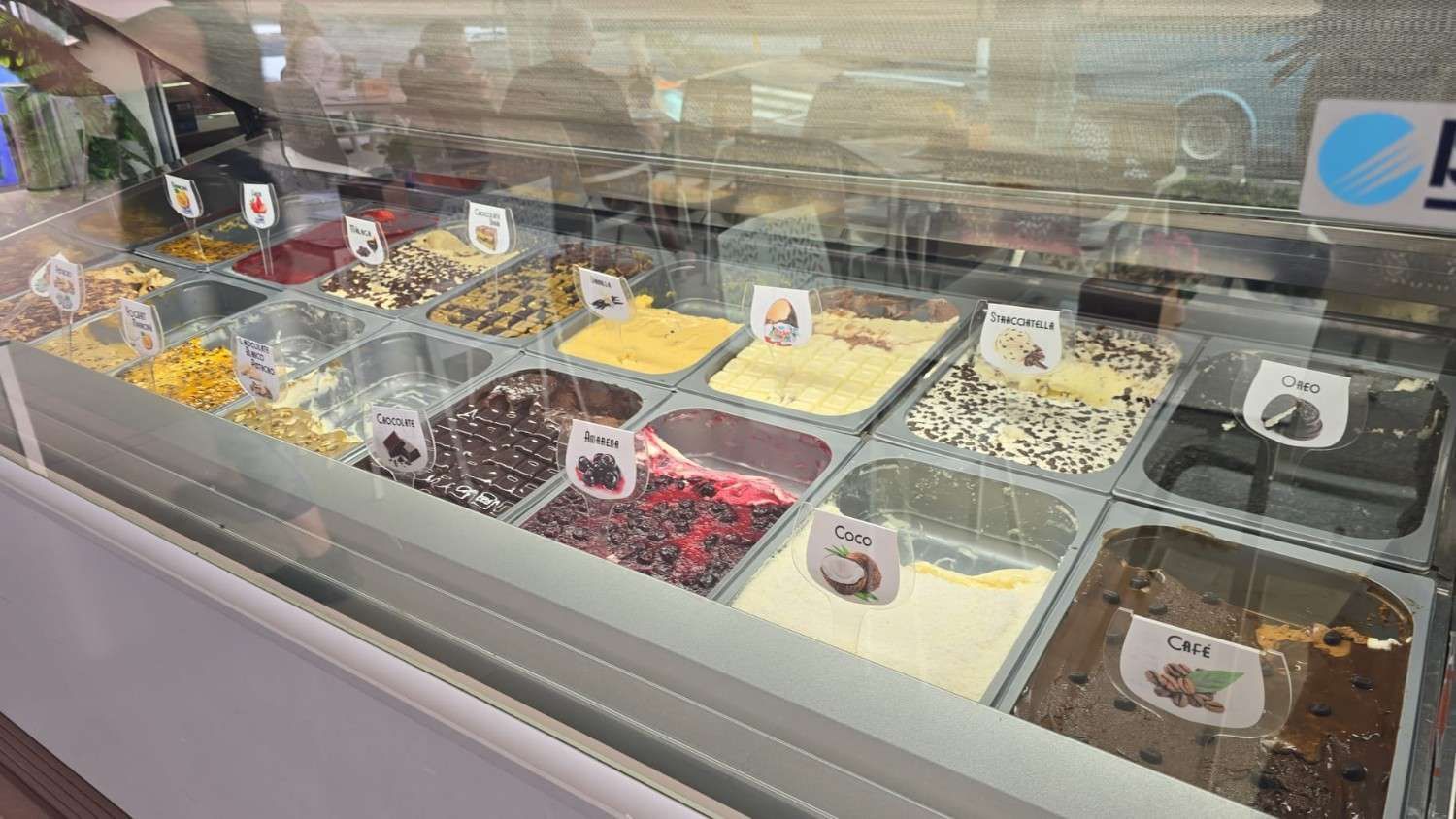 Vitrina llena de distintos sabores de helado.