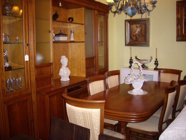 Un comedor con una mesa y sillas y una lámpara de araña.