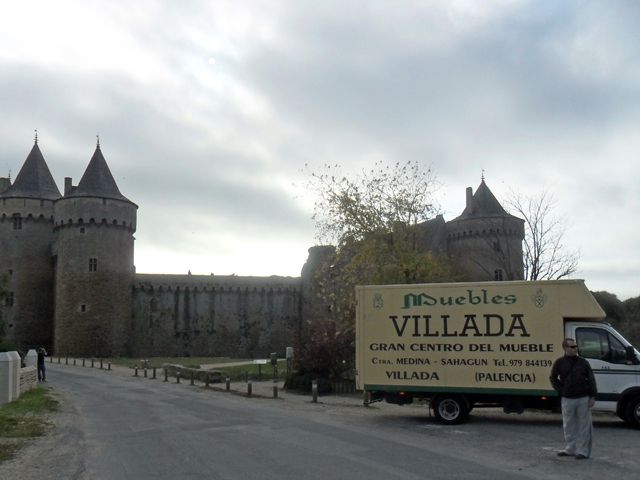 Un camión de muebles villada está estacionado frente a un castillo