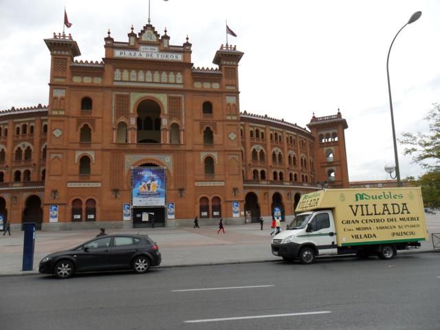 Un camión de villada está estacionado frente a un gran edificio.