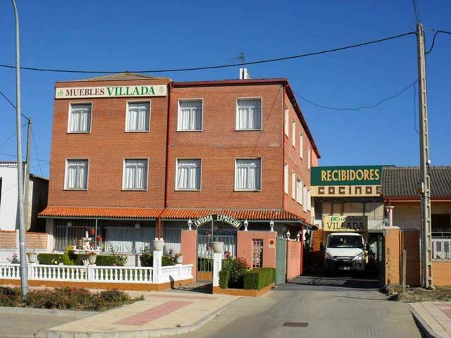 Un edificio de ladrillos con un cartel verde que dice recibidores