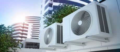 Zwei Klimaanlagen vor Hochhäusern