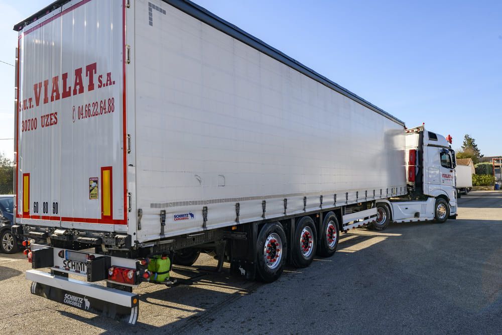 Semi-remorque blanche garée sur une route en plein jour