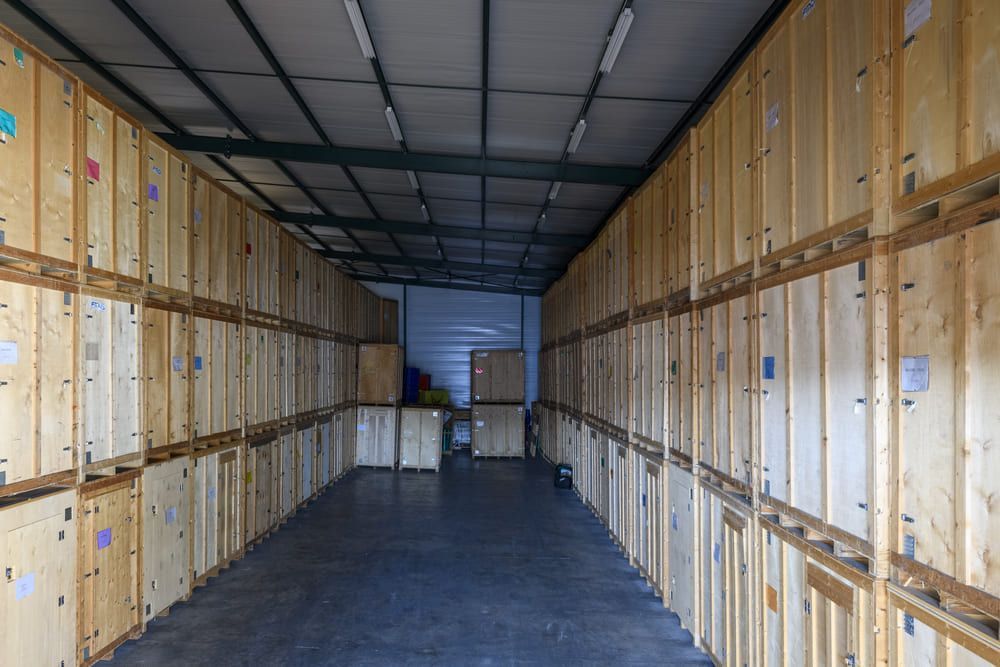 À l'intérieur d'une longue remorque de stockage aux parois et portes en bois, on aperçoit un sol sombre et vide ainsi qu'une extrémité ouverte.