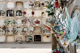 Un cementerio lleno de muchas tumbas y flores.