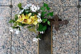 Una tumba con flores y una cruz sobre ella.