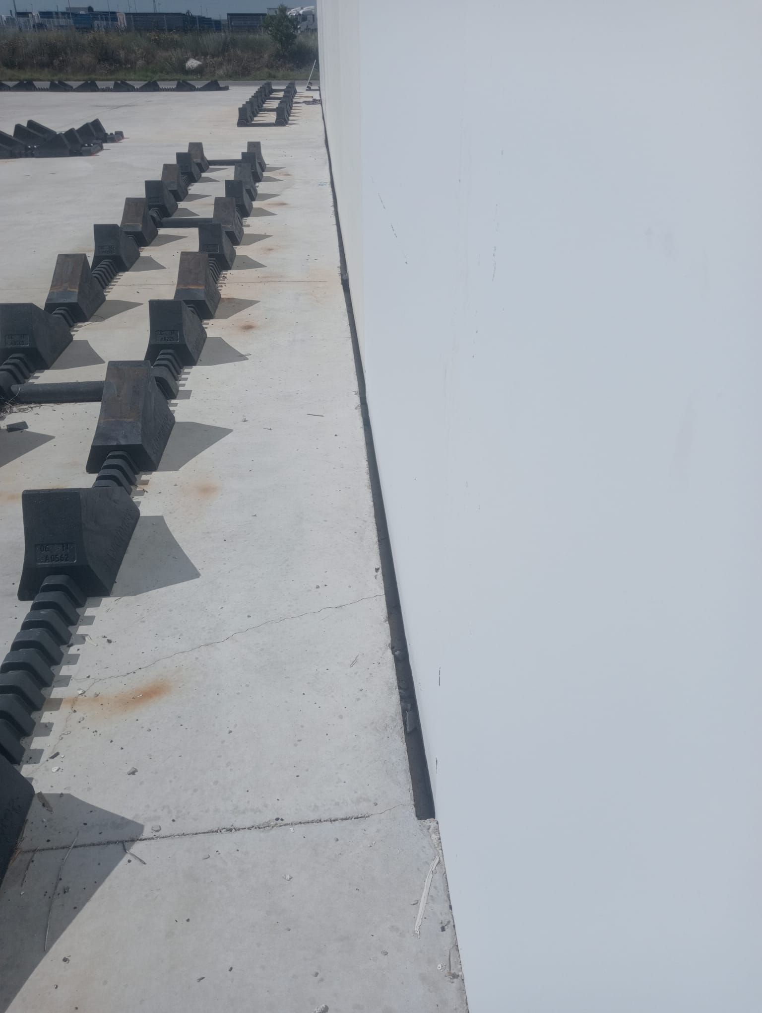 Una pared blanca con una fila de bloques negros sobre ella