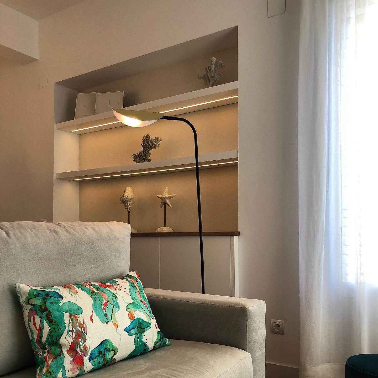 Una sala de estar con un sofá y una lámpara.