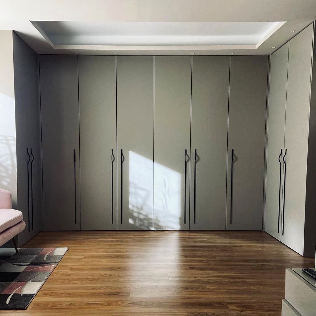 Una habitación con muchos armarios y pisos de madera.