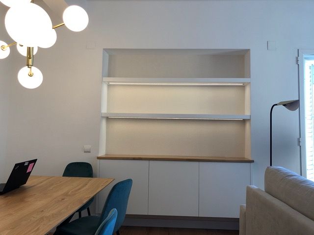 Una sala de estar con una mesa y sillas y una lámpara.