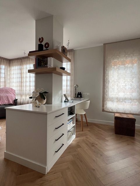 Una habitación con un escritorio y estantes.