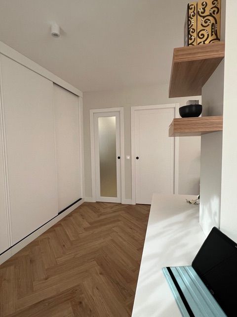 Una habitación con una puerta corrediza de vidrio y un escritorio.