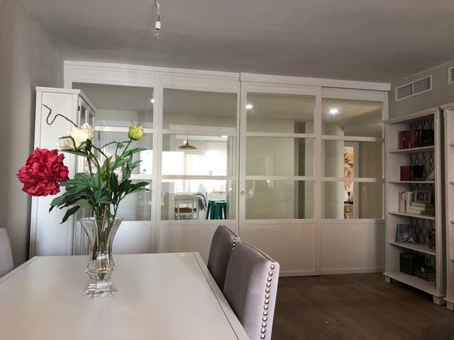 Un jarrón de flores reposa sobre una mesa en una sala de estar.