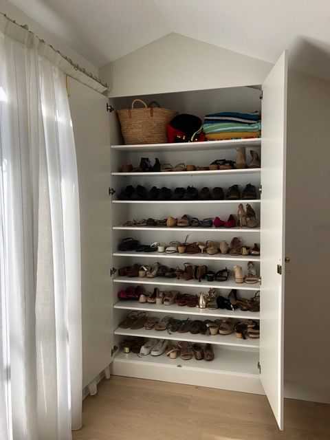 Un armario lleno de muchos zapatos y una cesta.