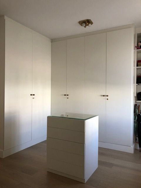 Una habitación con gabinetes blancos y una pequeña isla en el medio.