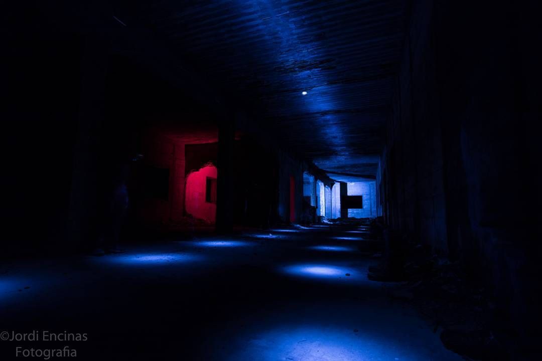 Un pasillo oscuro con luces azules y rojas en las paredes.