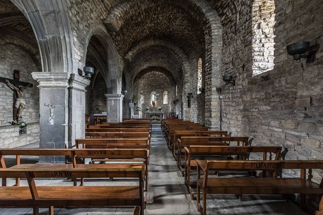 El interior de una iglesia con filas de bancos de madera.