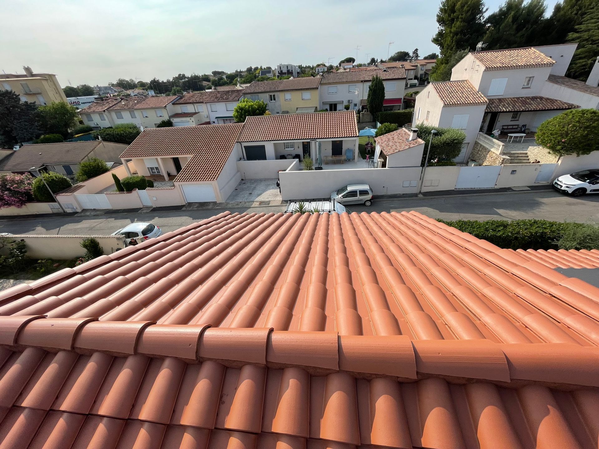 Vue en plongée d'une toiture en tuiles qui a été démoussée et nettoyée