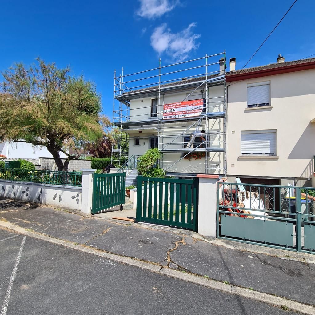 Une maison blanche avec un portail vert