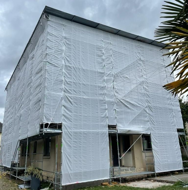 Une maison avec une protection sur les échafaudages