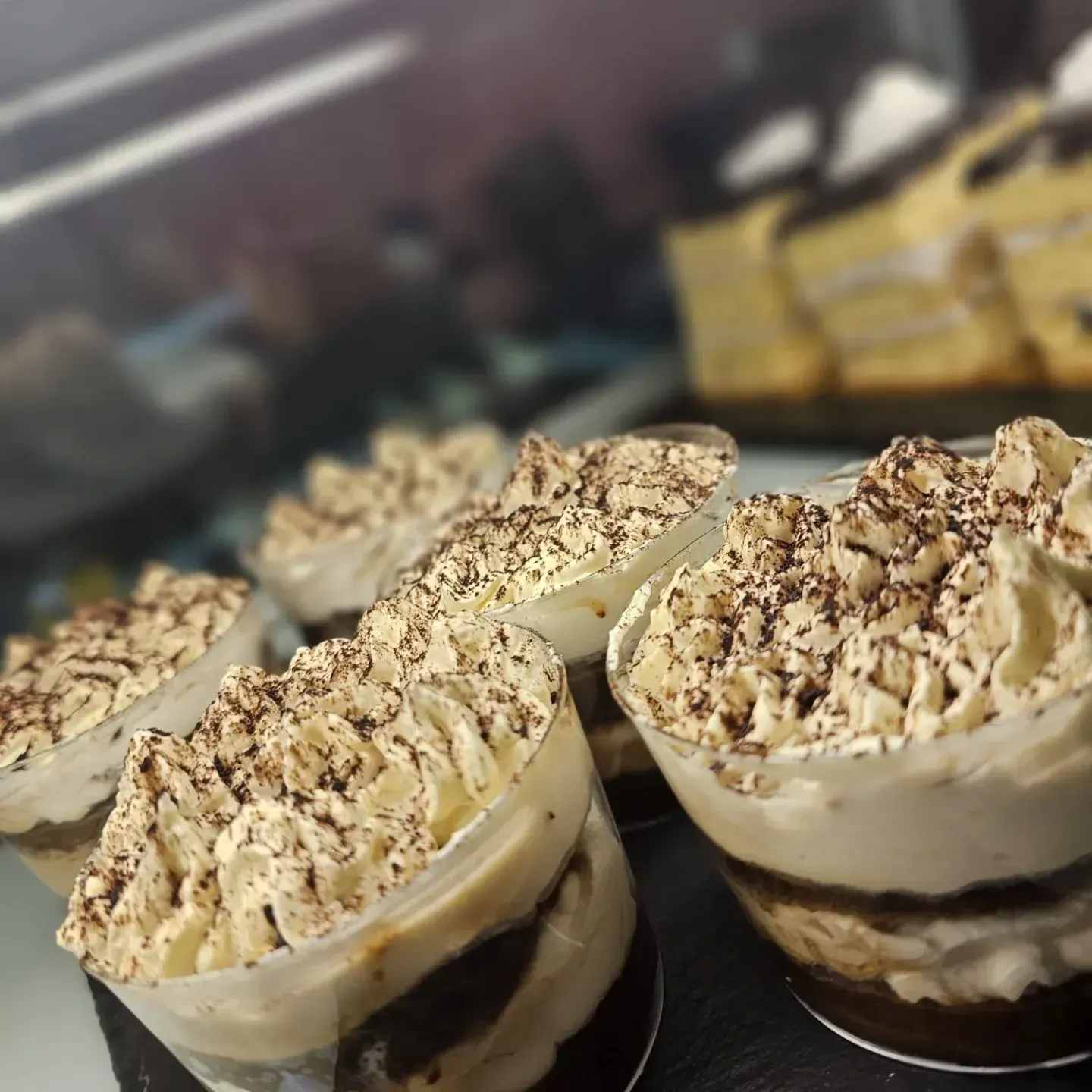 Una exhibición de postres con crema batida y virutas de chocolate.